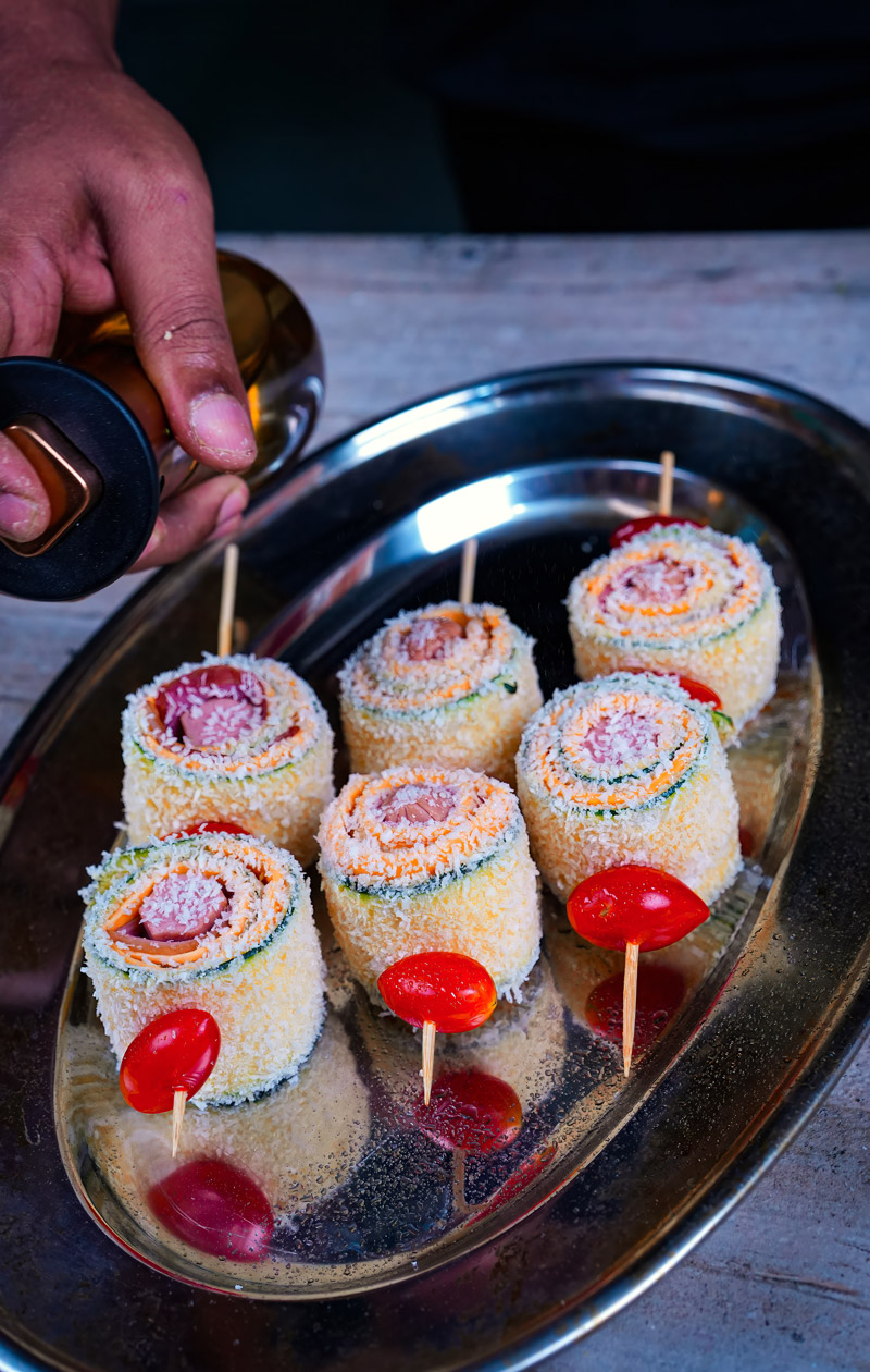 Assembled zucchini skewers with breadcrumbs and cherry tomatoes ready for baking.