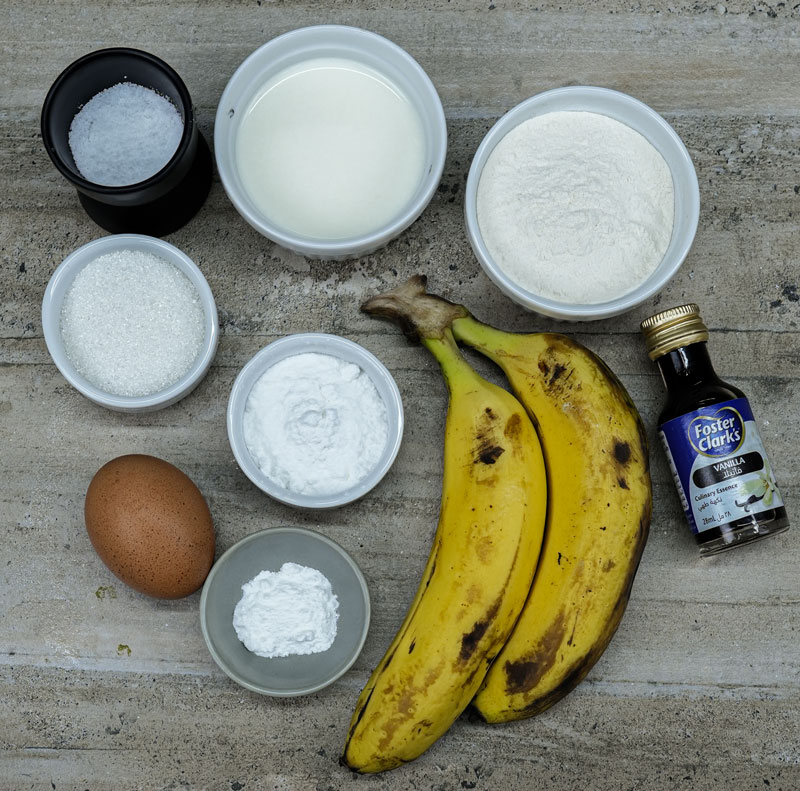 Ingredients for banana fritters including bananas, flour, and vanilla extract