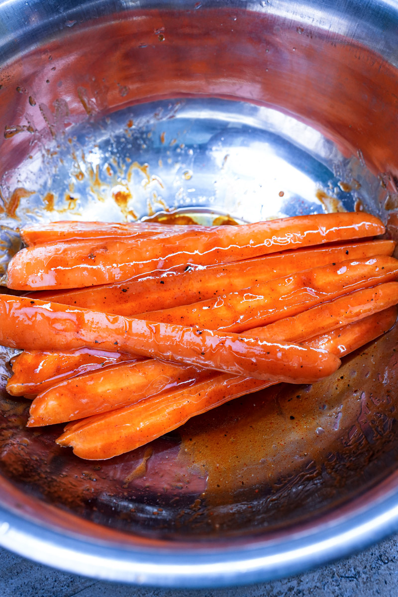 Glazed roasted carrots in a mixing bowl.