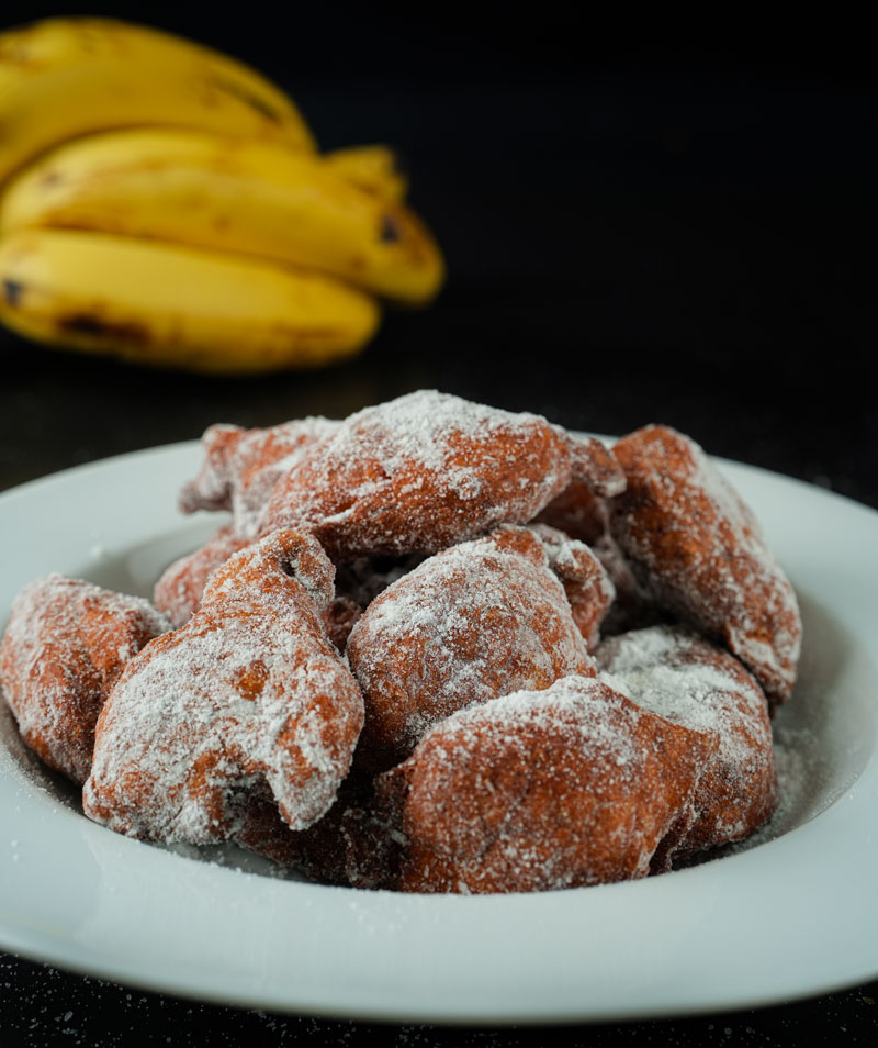 Close-up of banana fritters dusted with sugar