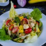 Fresh grilled chicken avocado salad with cherry tomatoes, onions, and lettuce.