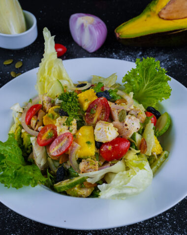 Fresh grilled chicken avocado salad with cherry tomatoes, onions, and lettuce.