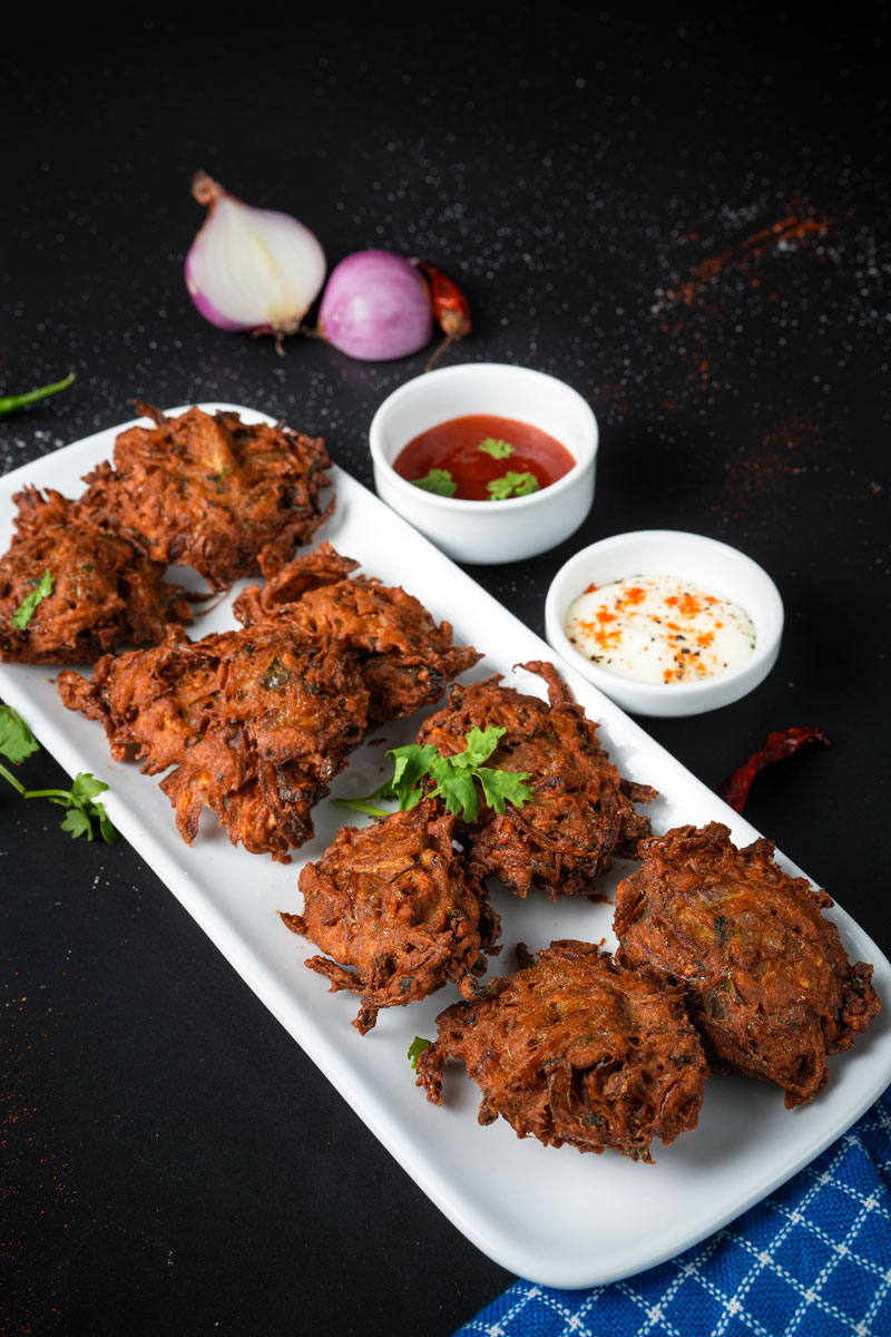 Onion fritters served with spicy chutney and yogurt d