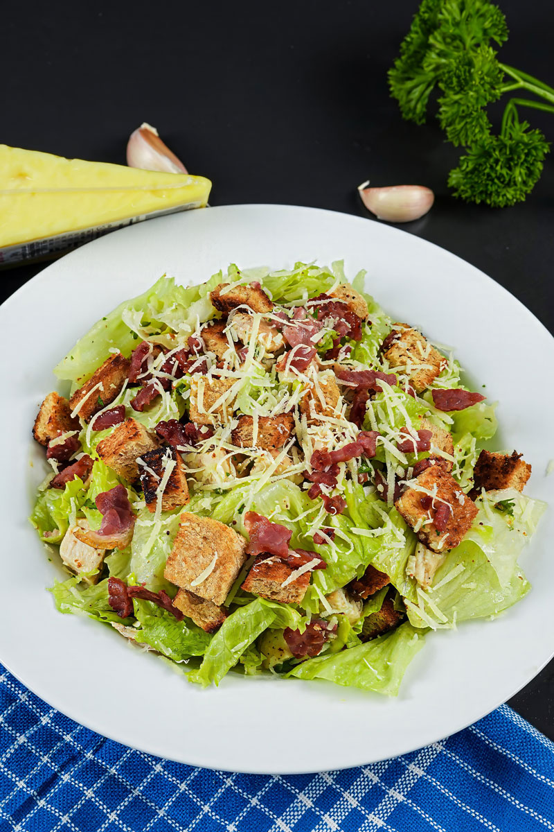 Fresh Chicken Caesar Salad topped with crispy croutons, bacon bits, and grated Parmesan.