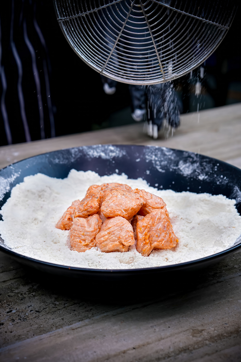 Fish cubes placed in flour for coating in Fish Popcorn recipe.