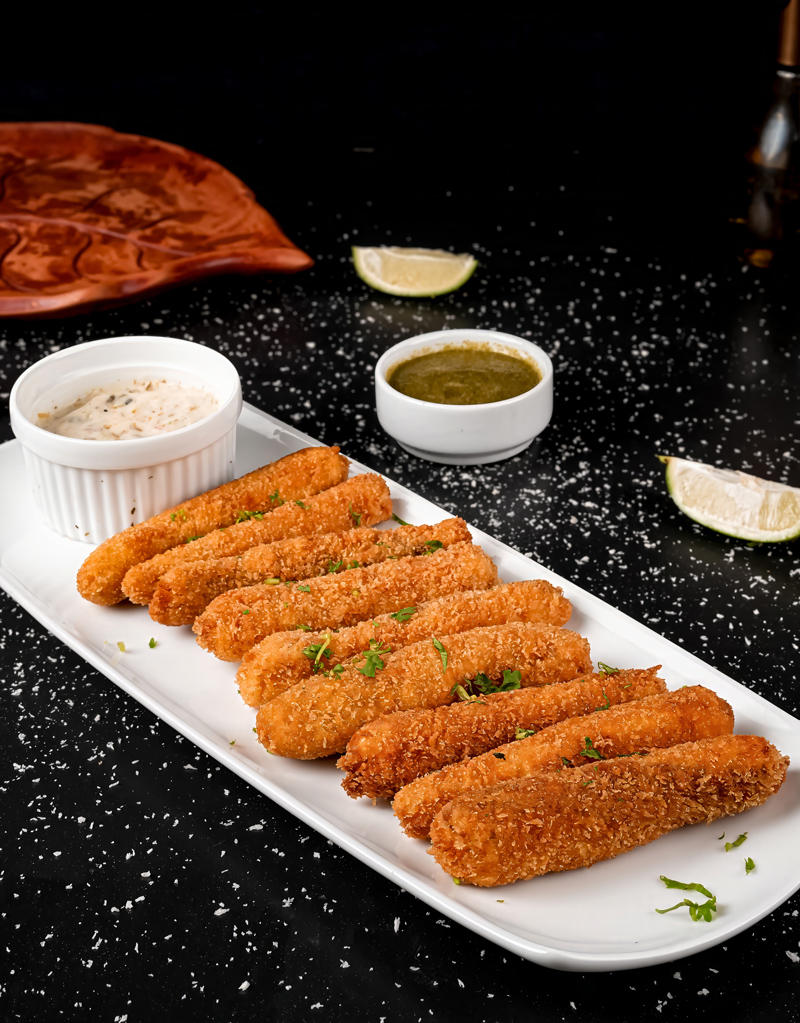 Close-up of golden fish sticks garnished with fresh parsley.