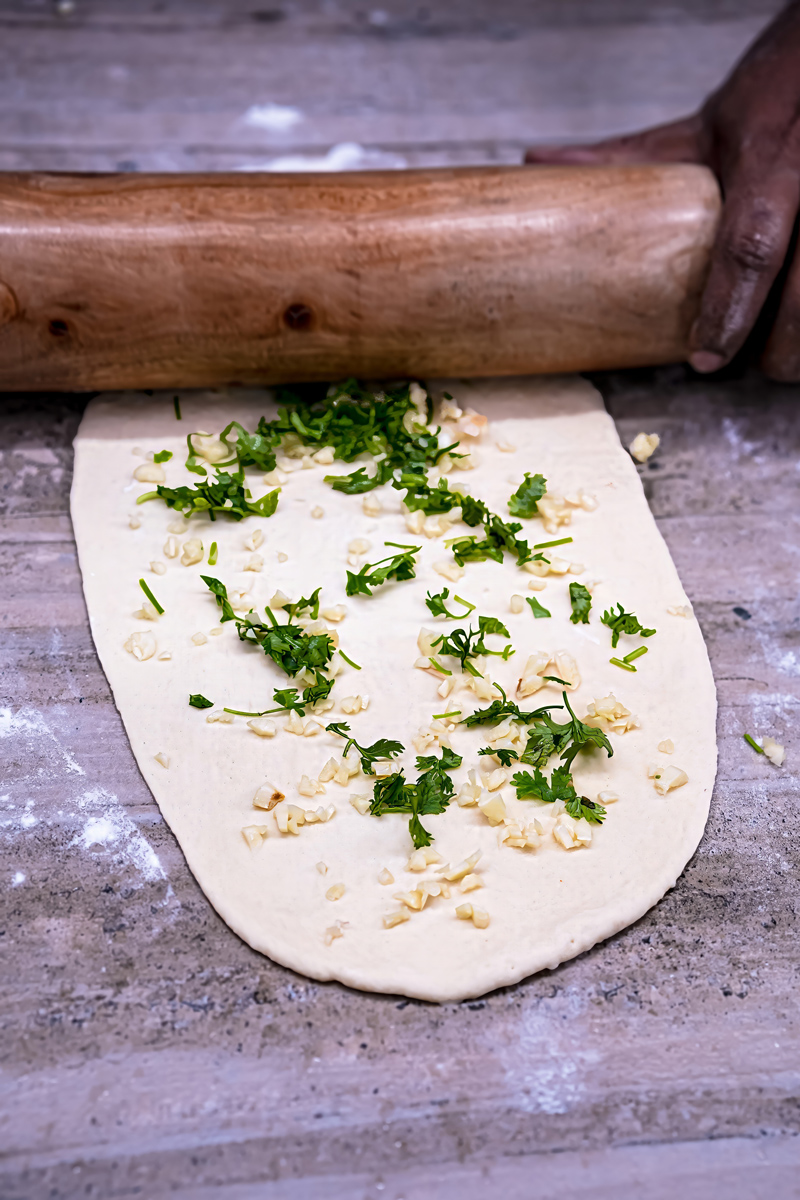 Freshly baked garlic naan with herbs and butter.