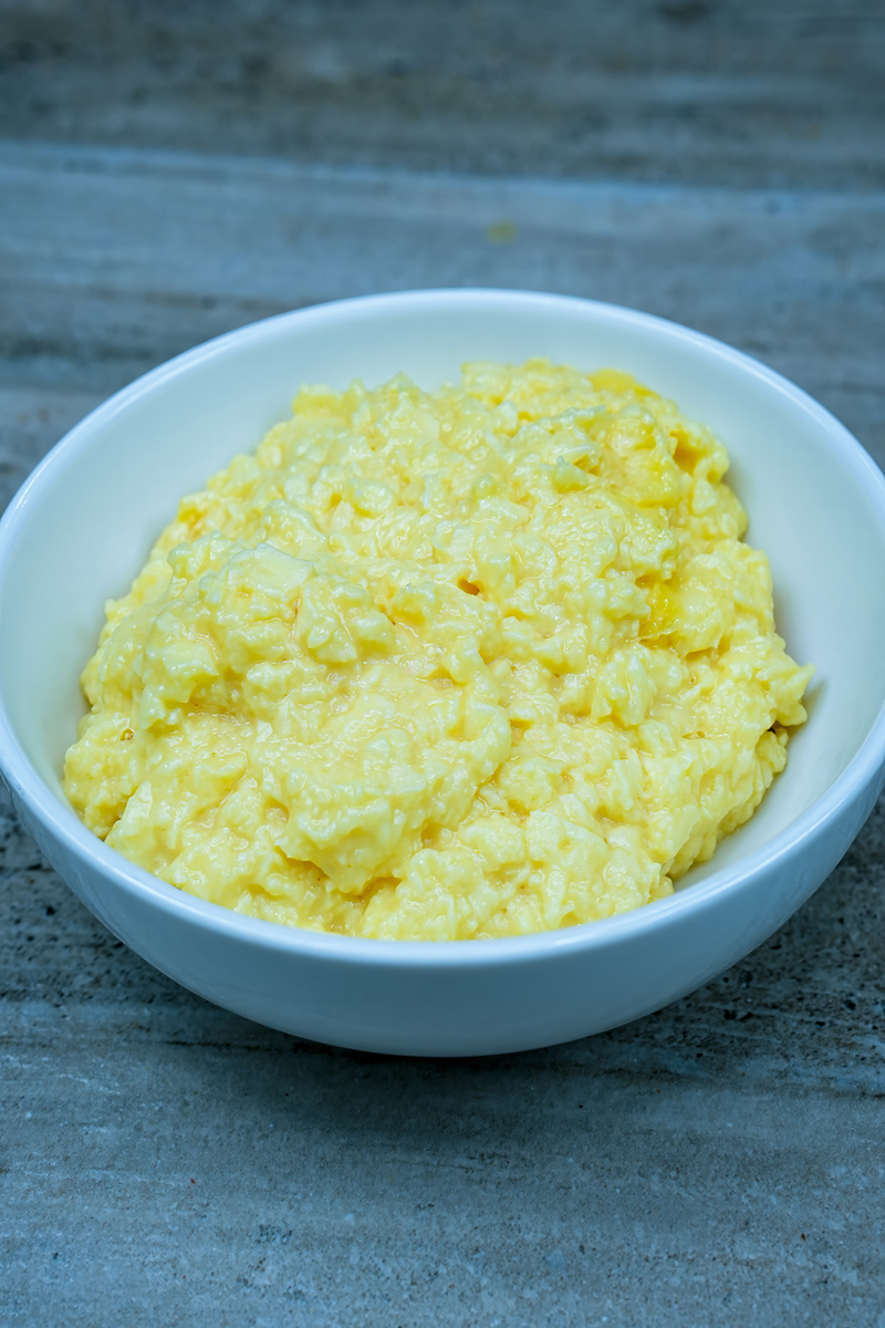 Creamy scrambled eggs served in a white bowl.