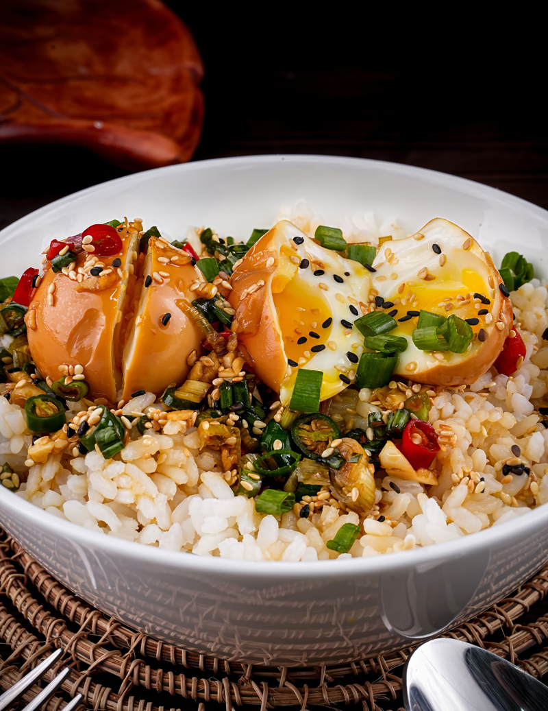 Spoonful of Mayak Eggs and rice with scallions and sesame garnish.