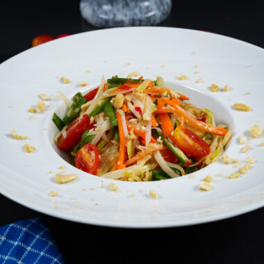 Freshly prepared Thai green papaya salad with shredded papaya and vibrant vegetables