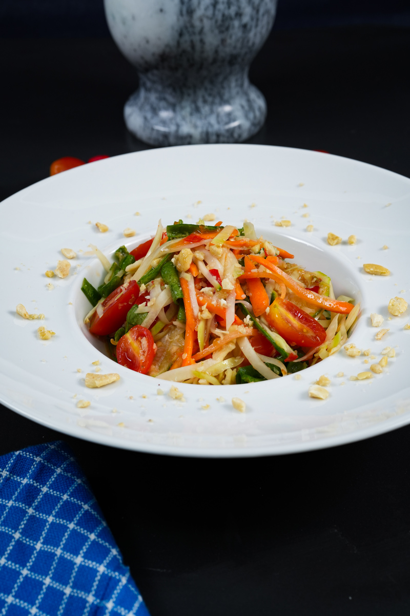 Freshly prepared Thai green papaya salad with shredded papaya and vibrant vegetables