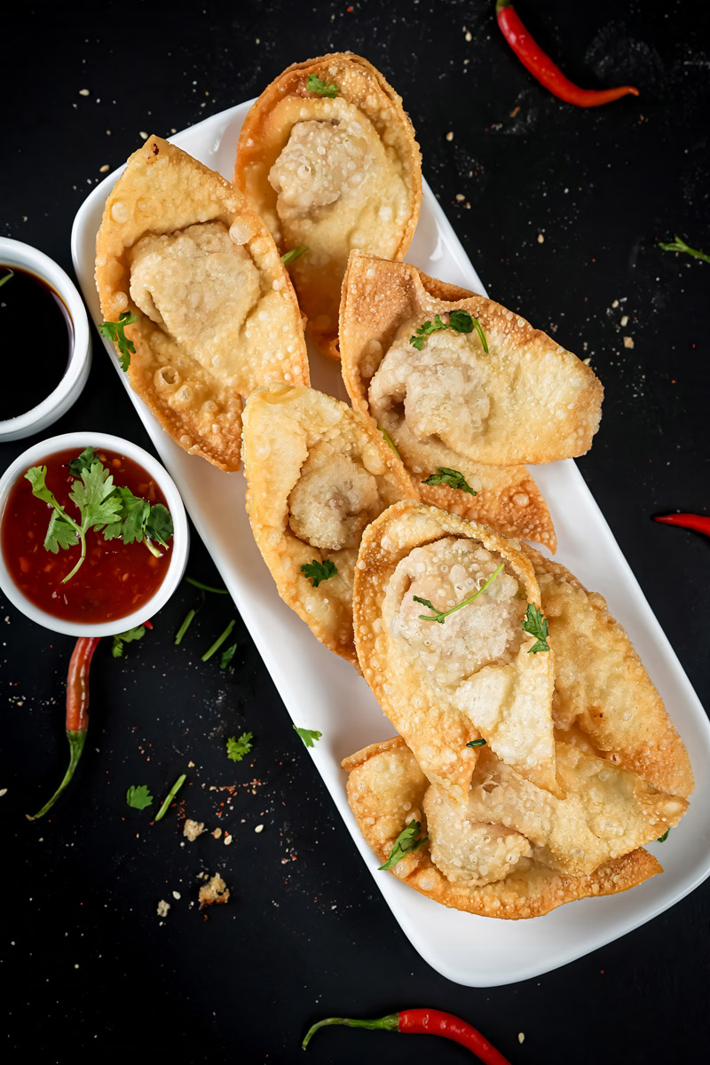 A delicious serving of crunchy shrimp wontons with dipping sauce.