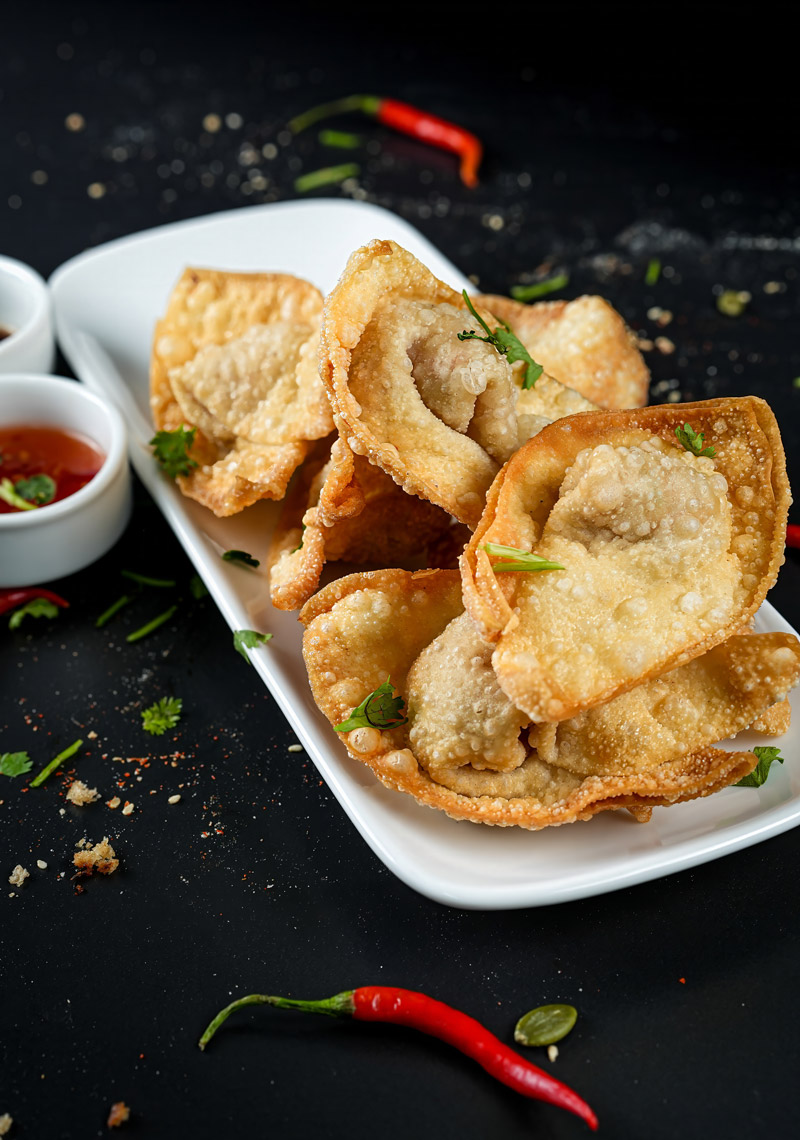 Golden, crispy shrimp wontons sprinkled with herbs and ready to serve.