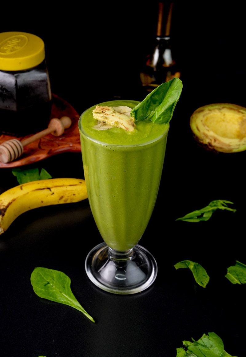 Avocado spinach smoothie with honey and fresh ingredients