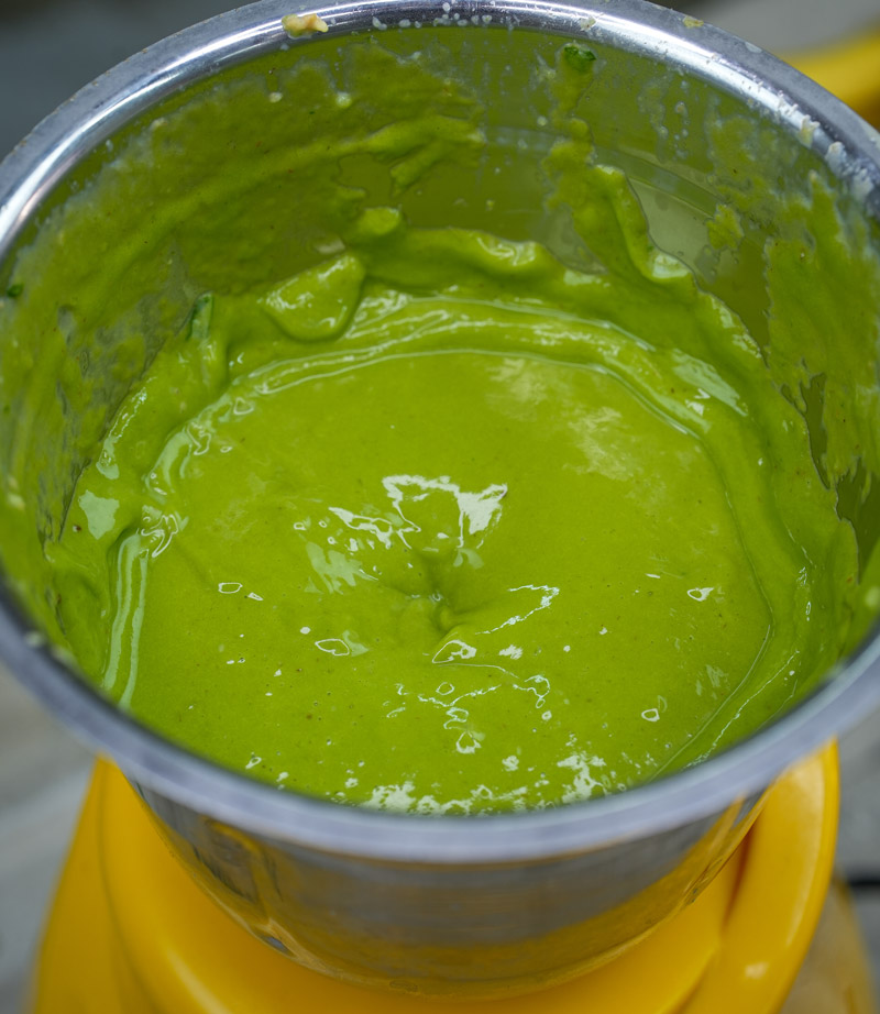 Blended avocado spinach smoothie mixture in blender