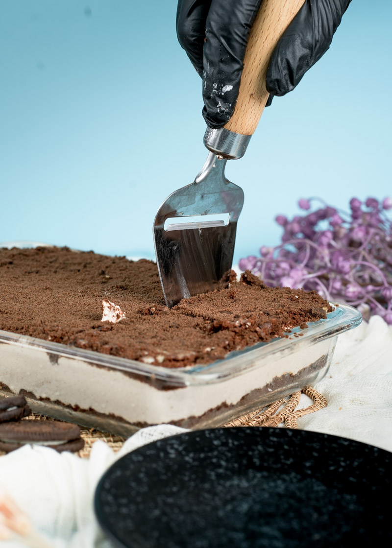 Cutting into freshly made Oreo dirt cake dessert
