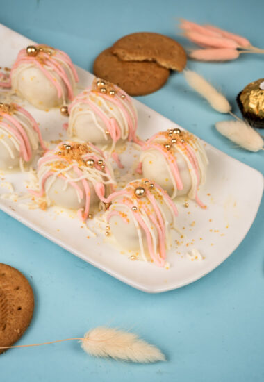 Elegant platter of white chocolate digestive cake balls with cookies and decorative elements