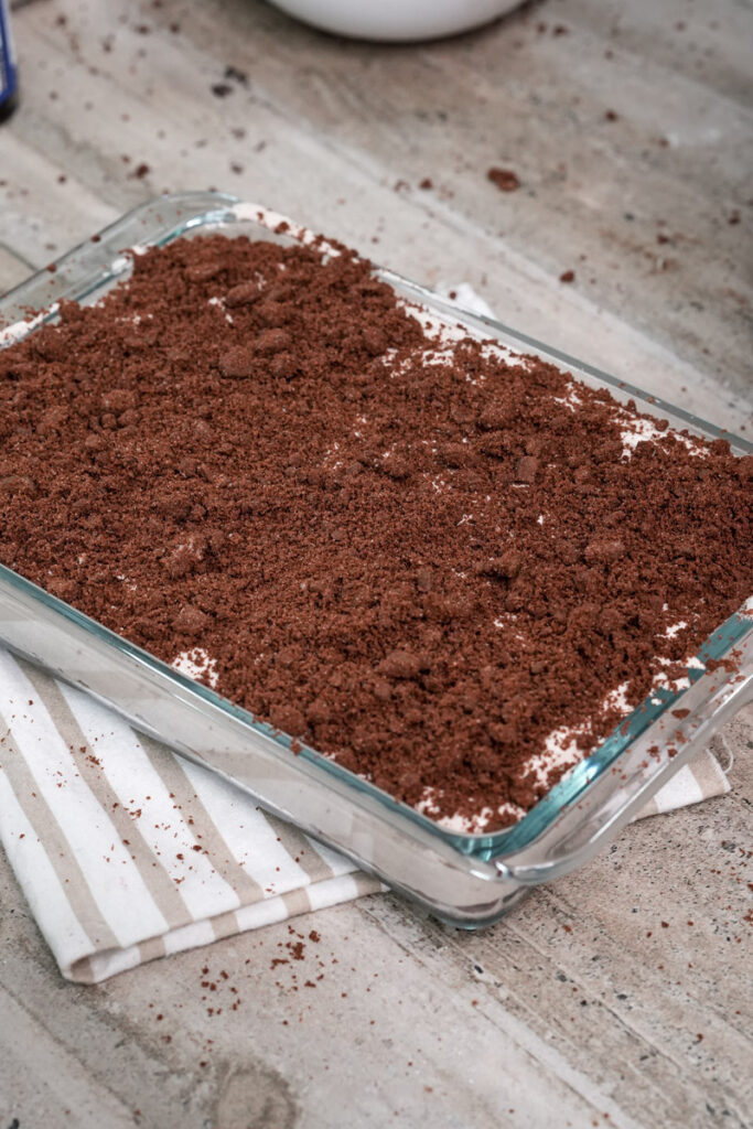 Finished Oreo dirt cake in glass baking dish with chocolate topping