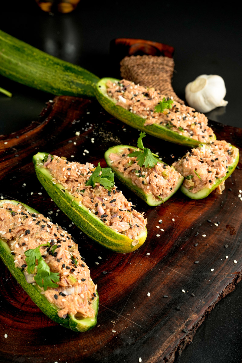 Healthy tuna-stuffed cucumber boats on rustic wooden serving platter