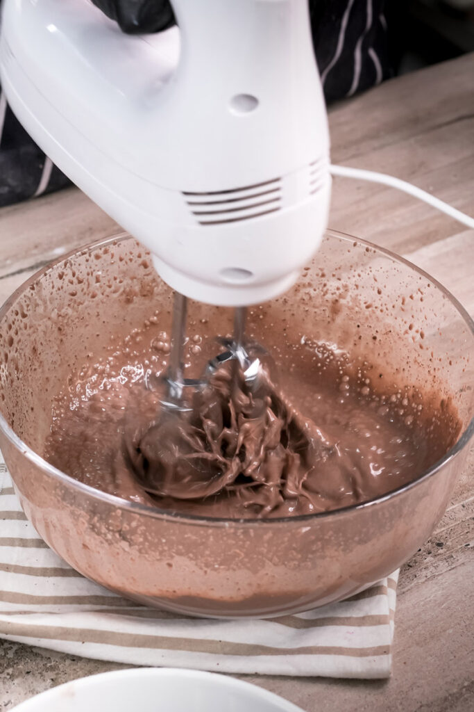 Mixing chocolate pudding with hand mixer for dirt cake