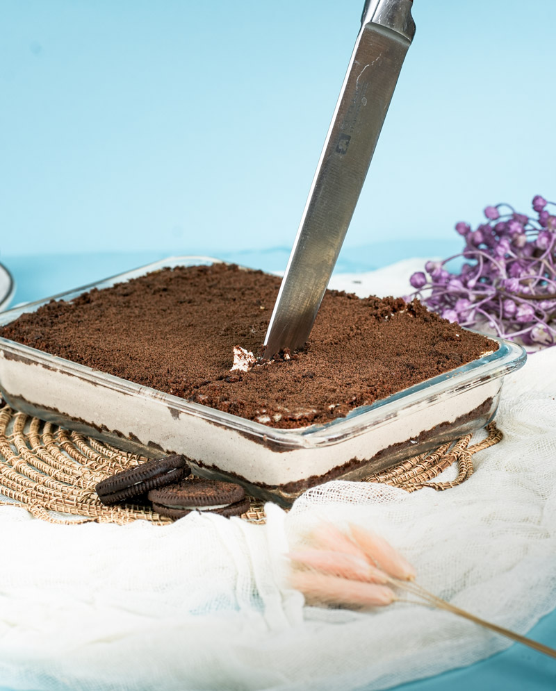 Oreo dirt cake with serving knife showing layers and texture