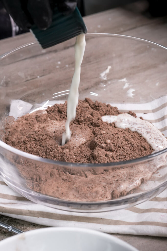 Pouring milk into Oreo dirt cake mixture