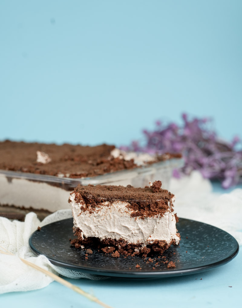 Side view of layered Oreo dirt cake with cookie crumb topping