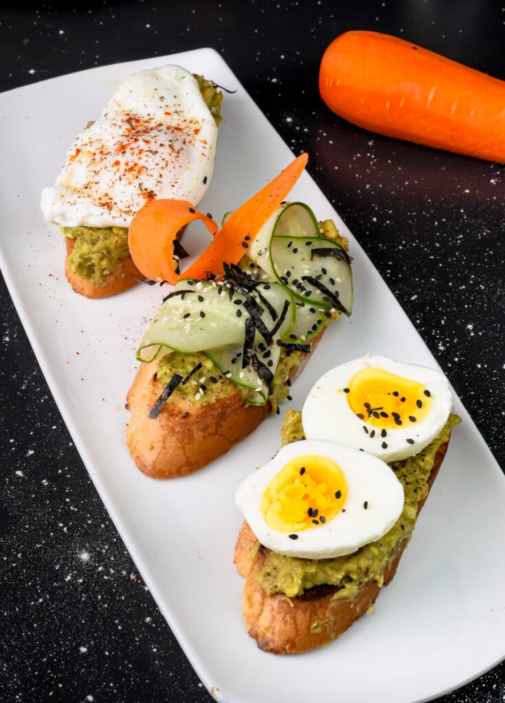 Close-up of avocado toast varieties with perfectly cooked eggs