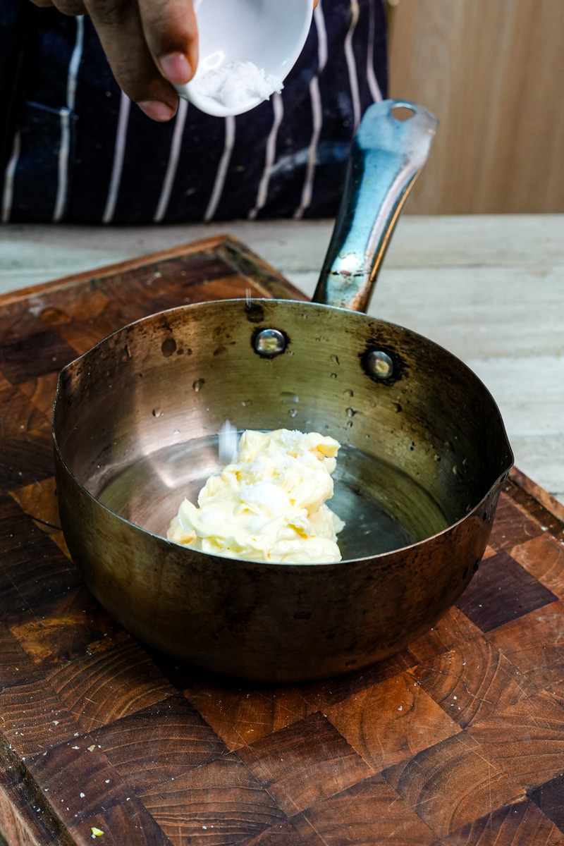 Adding flour to melted butter mixture while making homemade eclair dough