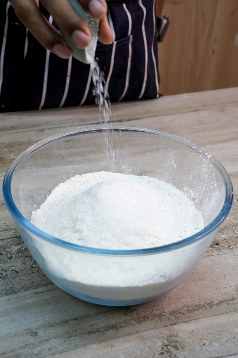 Adding salt to flour for empanada dough base