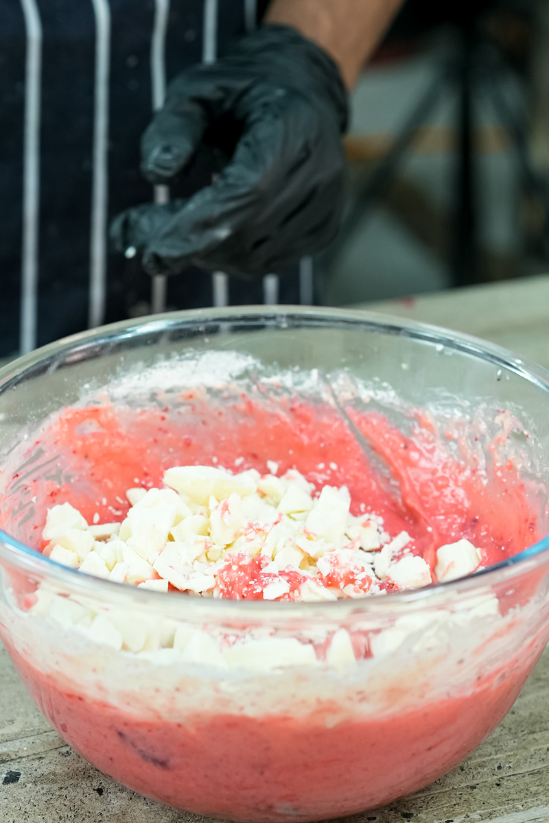 Adding white chocolate chunks to pink strawberry cake batter