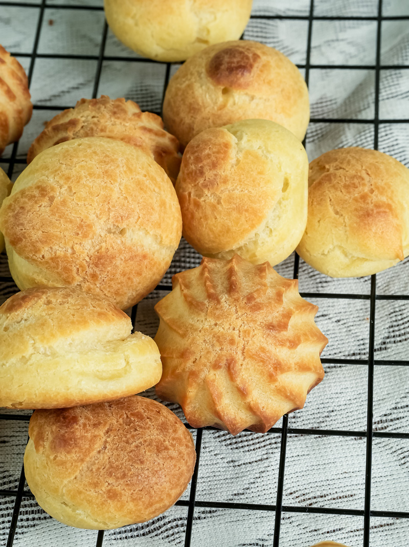 Baked choux pastry with different textures on wire rack