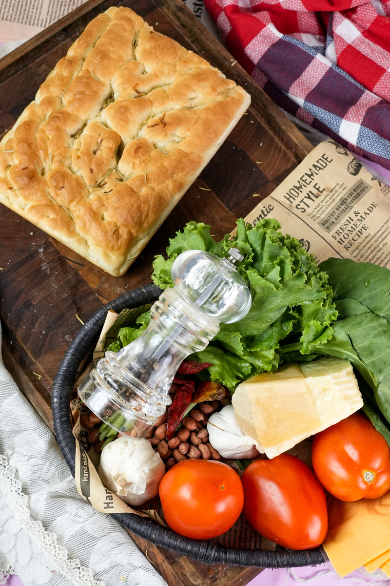 Baked focaccia bread with fresh sandwich ingredients and vegetables