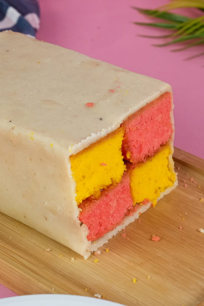 Complete Battenberg cake with marzipan coating on cutting board