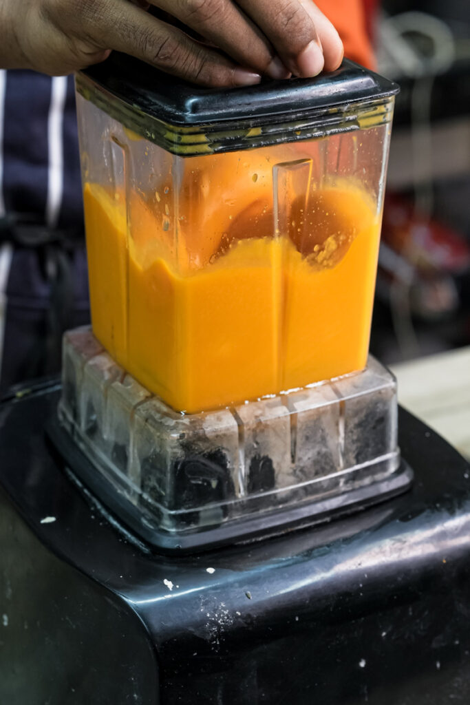 Blending fresh mango pieces for homemade mango muffins