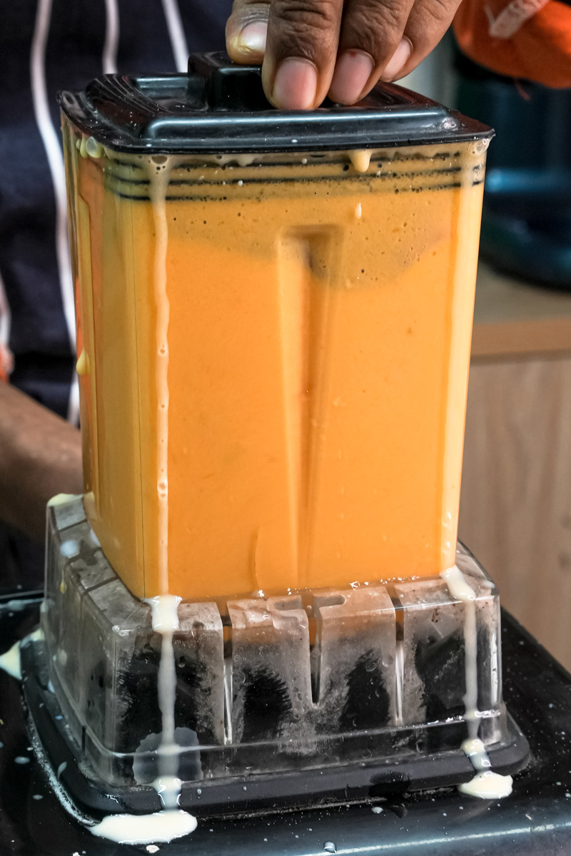Blending mango milkshake ingredients in high-speed blender