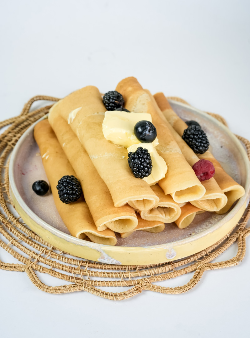 Breakfast pancake rolls garnished with fresh berries and butter