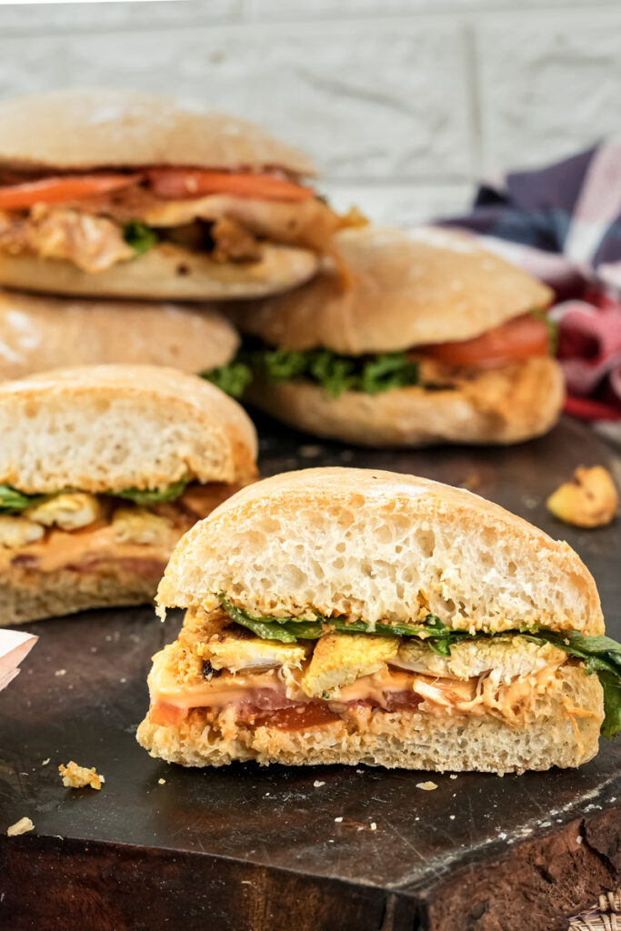 Ciabatta sandwich cross-section with ham, cheese and greens