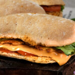 Ciabatta sandwich cross-section showing cheese and bacon layers