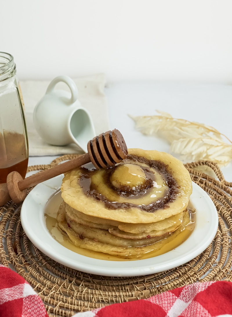 Cinnamon roll pancake recipe with honey drizzle and milk jar