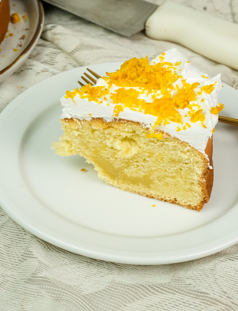 Citrus cake slice with cream cheese frosting and orange zest