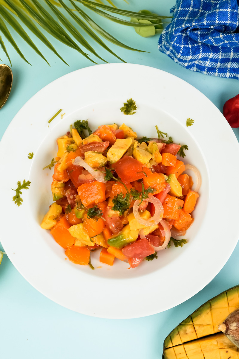 Colorful mango avocado salad served on white plate