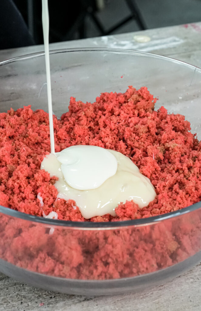 Combining frosting and cake crumbs to form strawberry cake pop dough