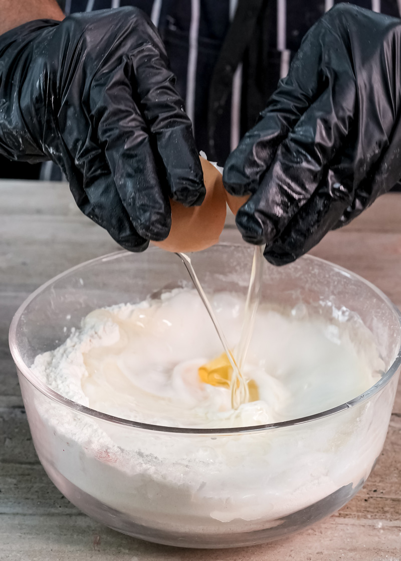 Cracking fresh egg into gluten free pancake flour mixture
