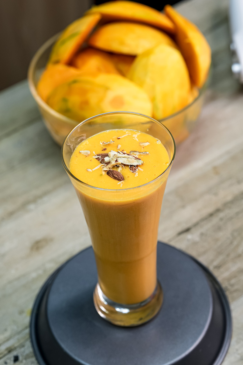 Creamy mango milkshake garnished with chopped nuts