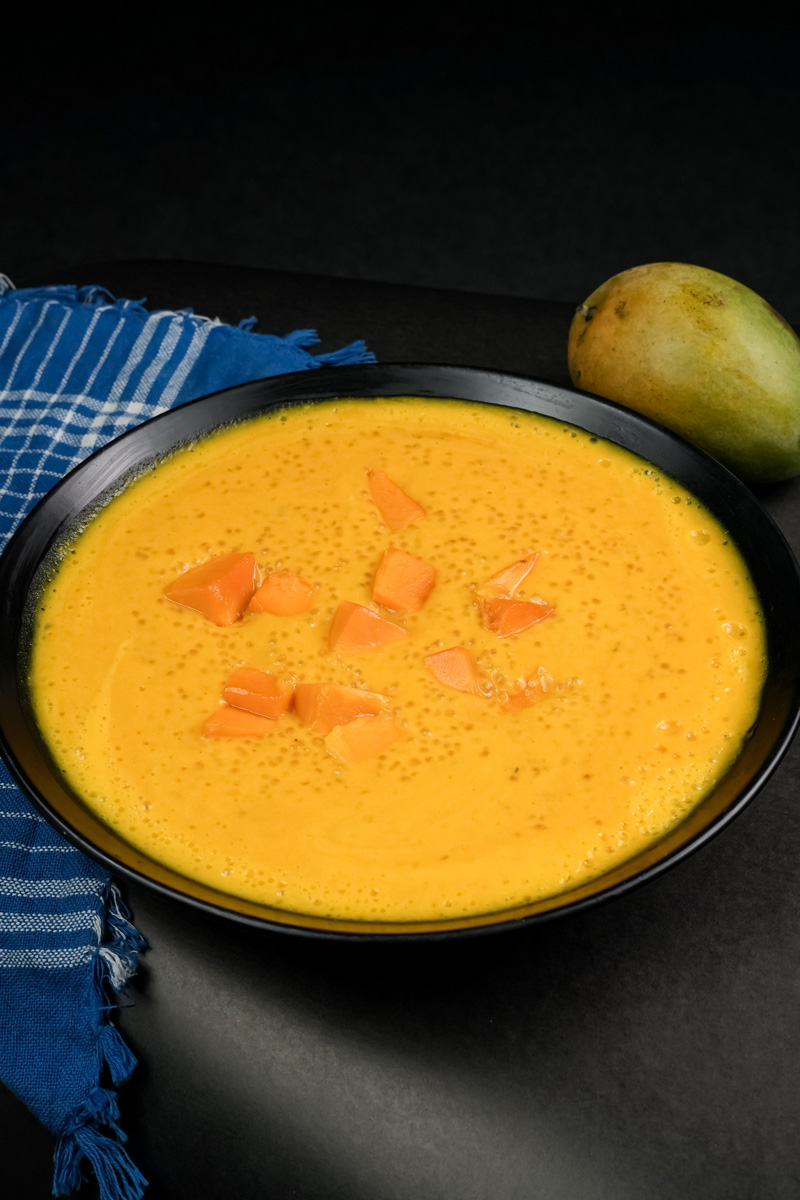 Creamy mango sago dessert garnished with fresh mango chunks