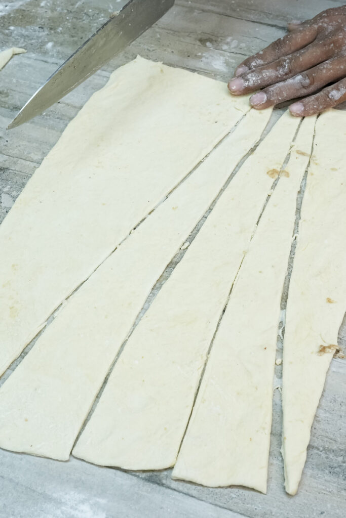 Croissant dough strips cut into triangles for shaping