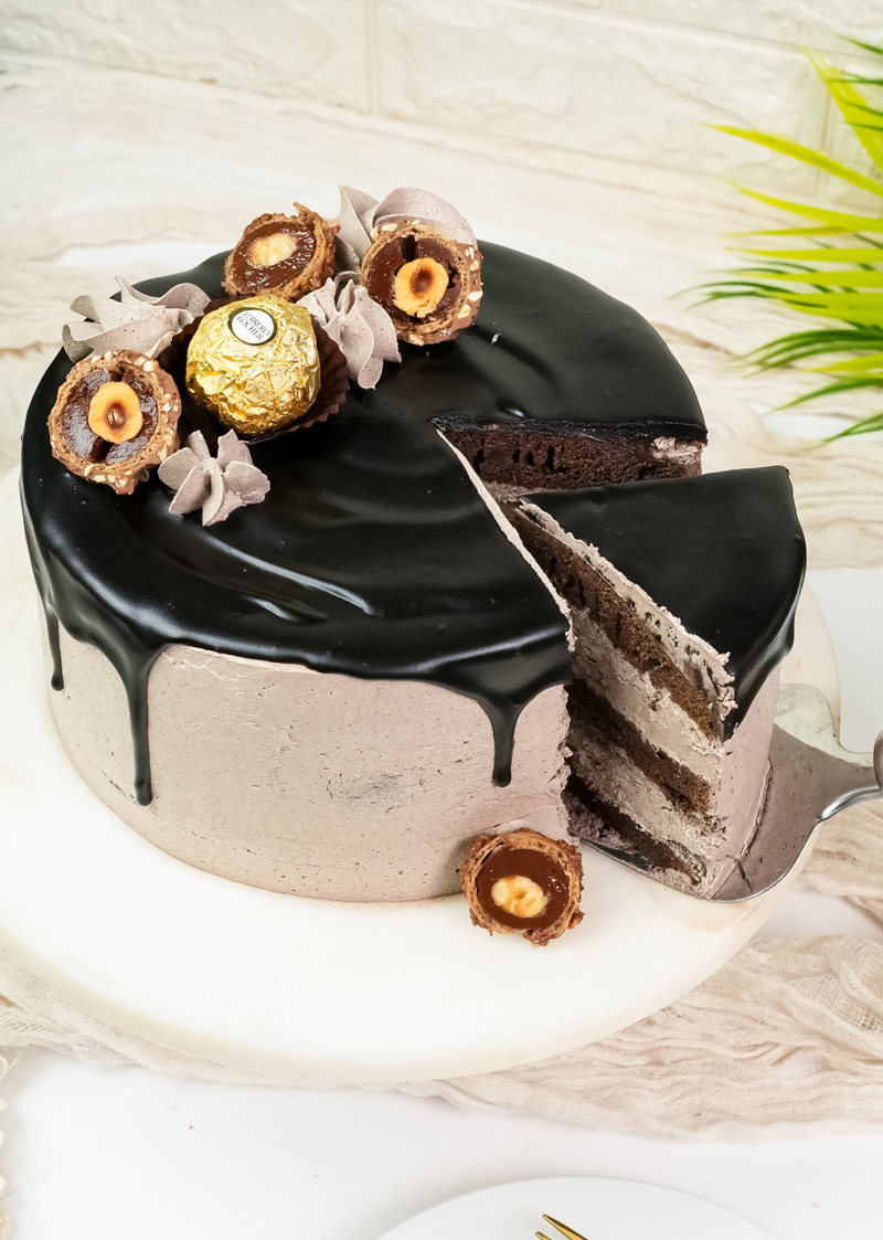 Cut Ferrero Rocher cake showing internal chocolate sponge layers