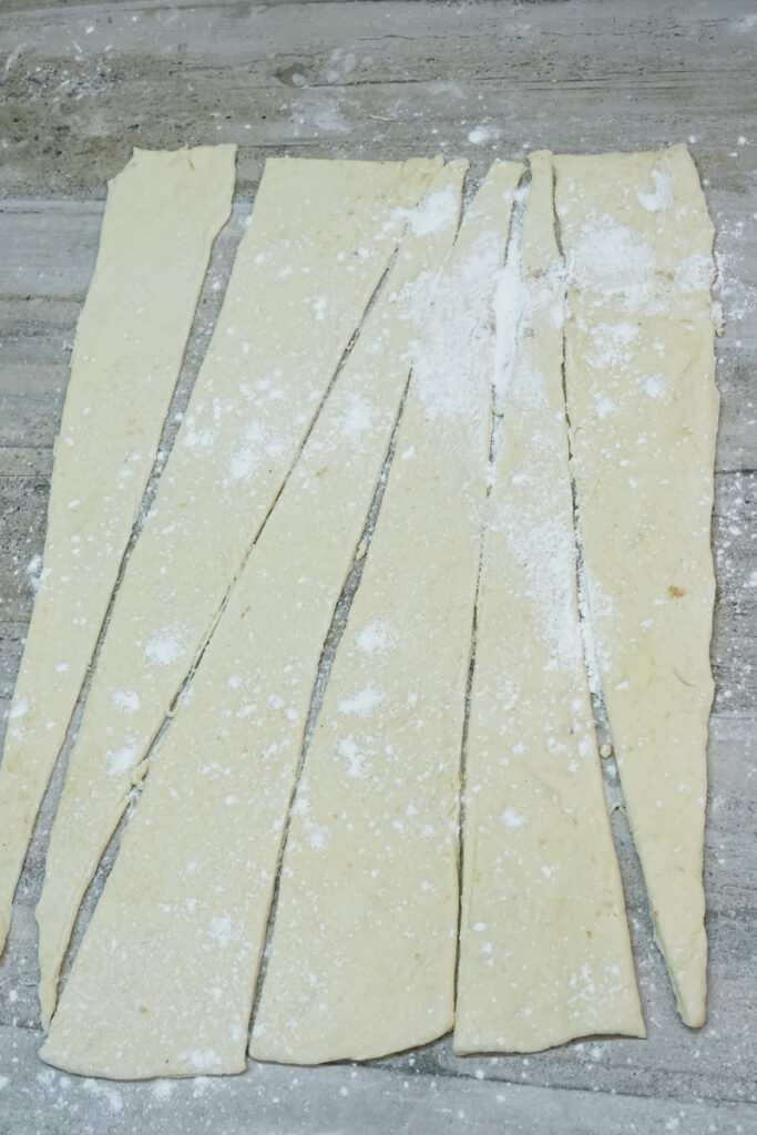 Cut croissant dough pieces ready for rolling