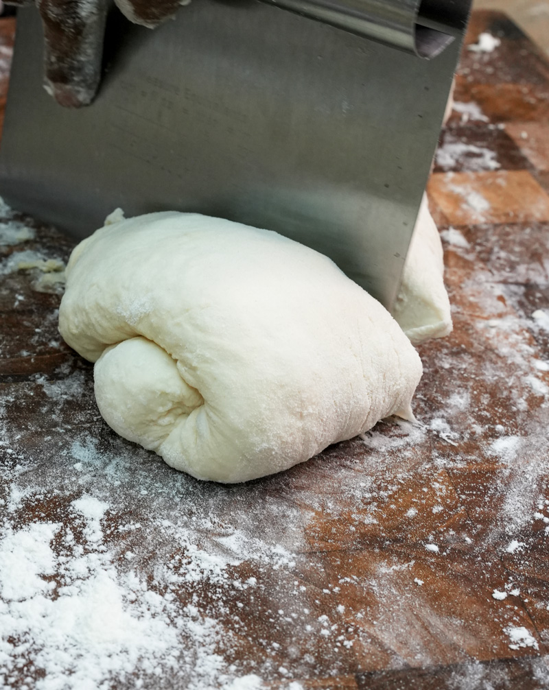 Cutting ciabatta dough into portions with bench scraper